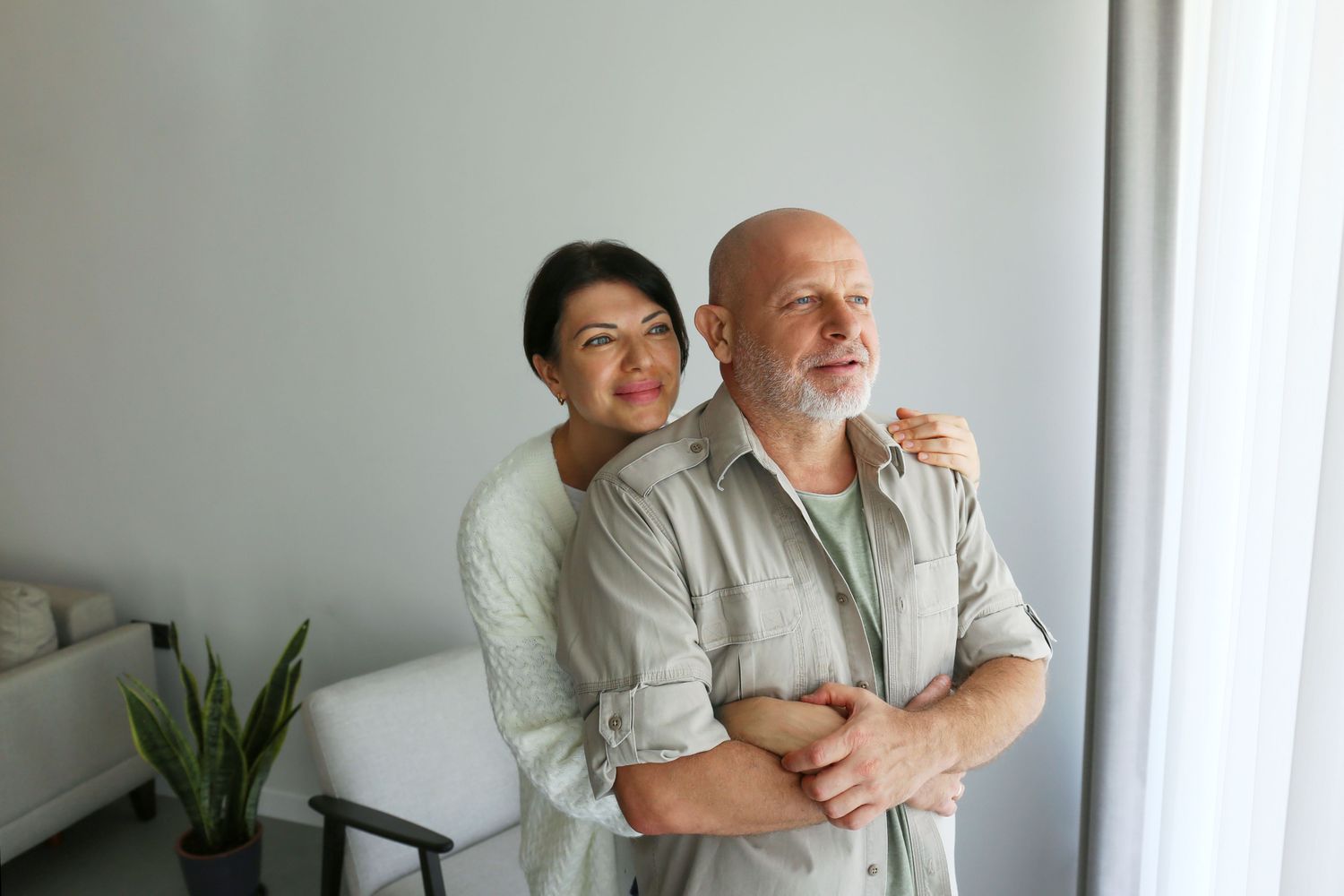 A mature couple in a home setting providing emotional support, representing patient recovery.