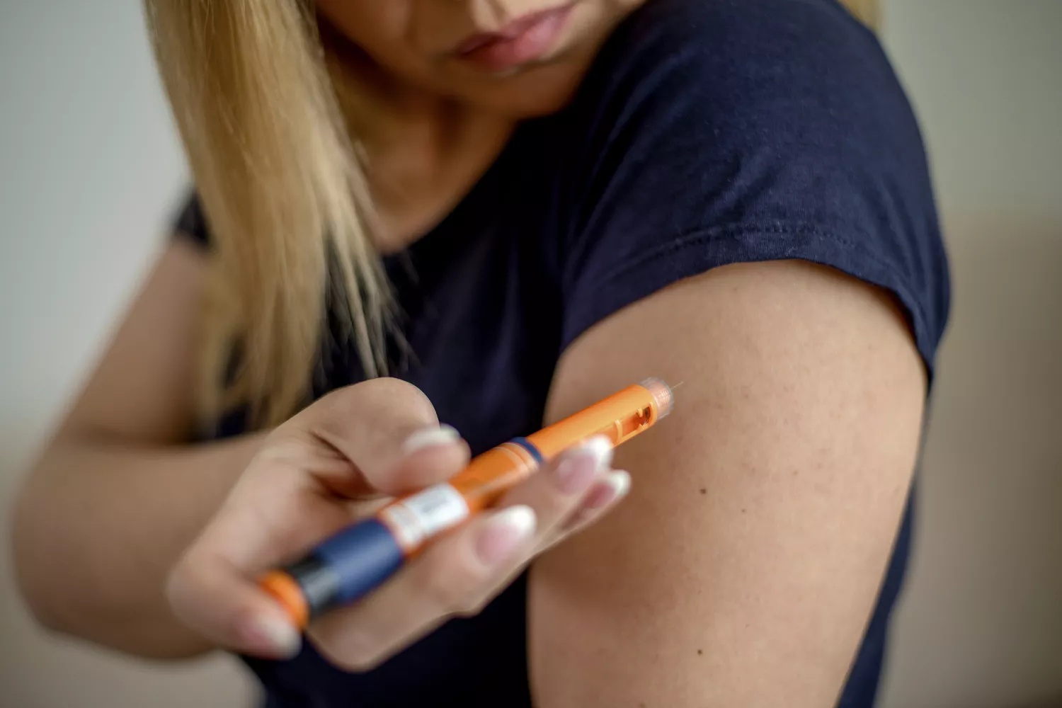 A patient engaging in a healthcare routine involving self-administered medication.