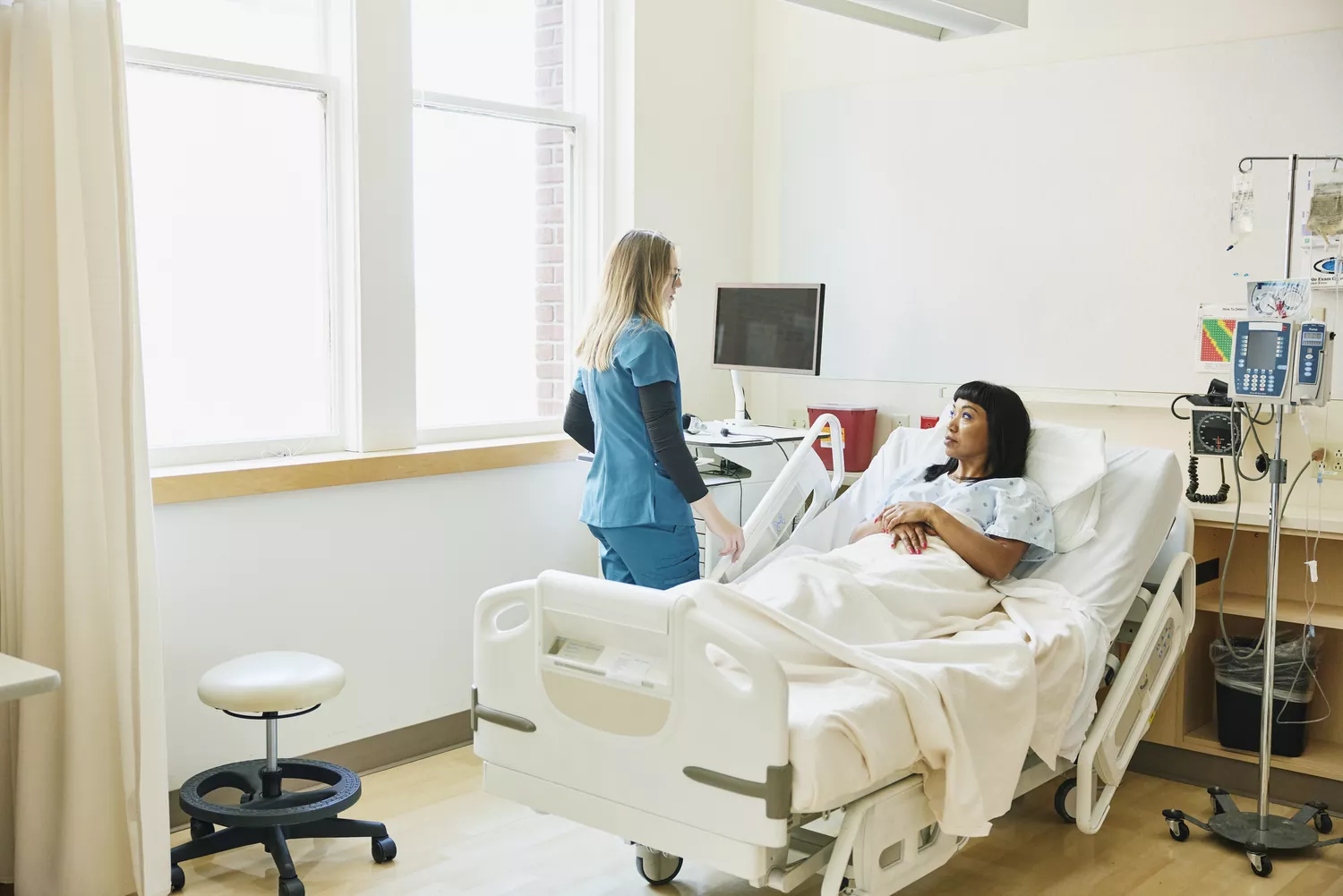 A wide shot of a healthcare provider in a professional setting consulting with a patient.
