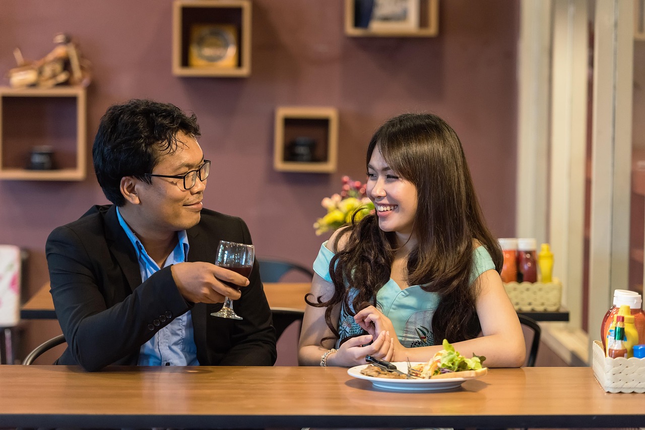 A woman smiling while eating a fresh green salad outdoors