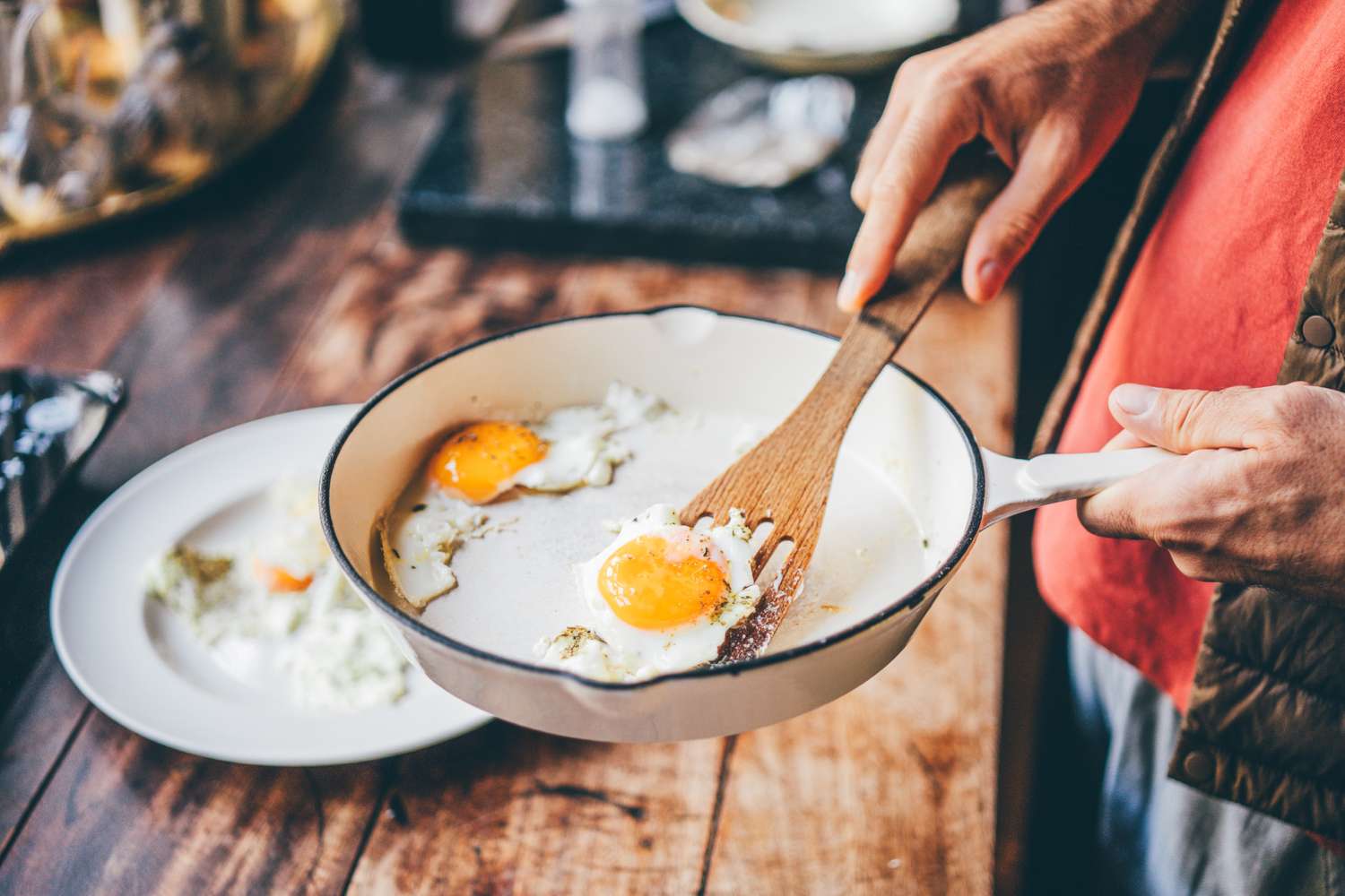 Cooking eggs in a pan with a wooden spatula.