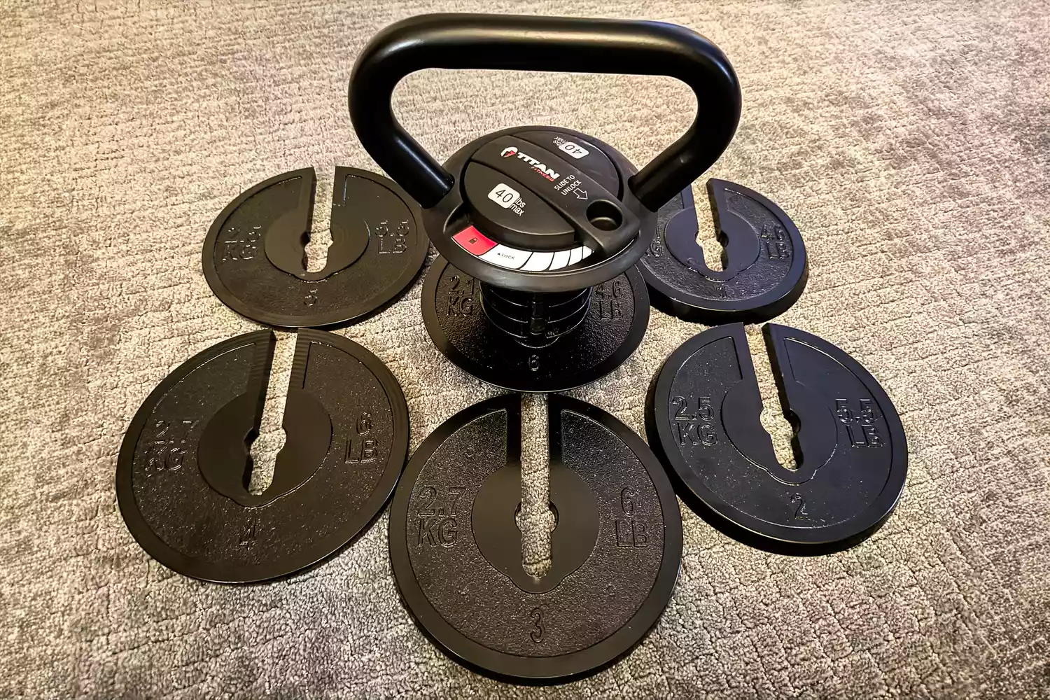 Titan Fitness adjustable kettlebell with its internal plates removed and displayed side-by-side.