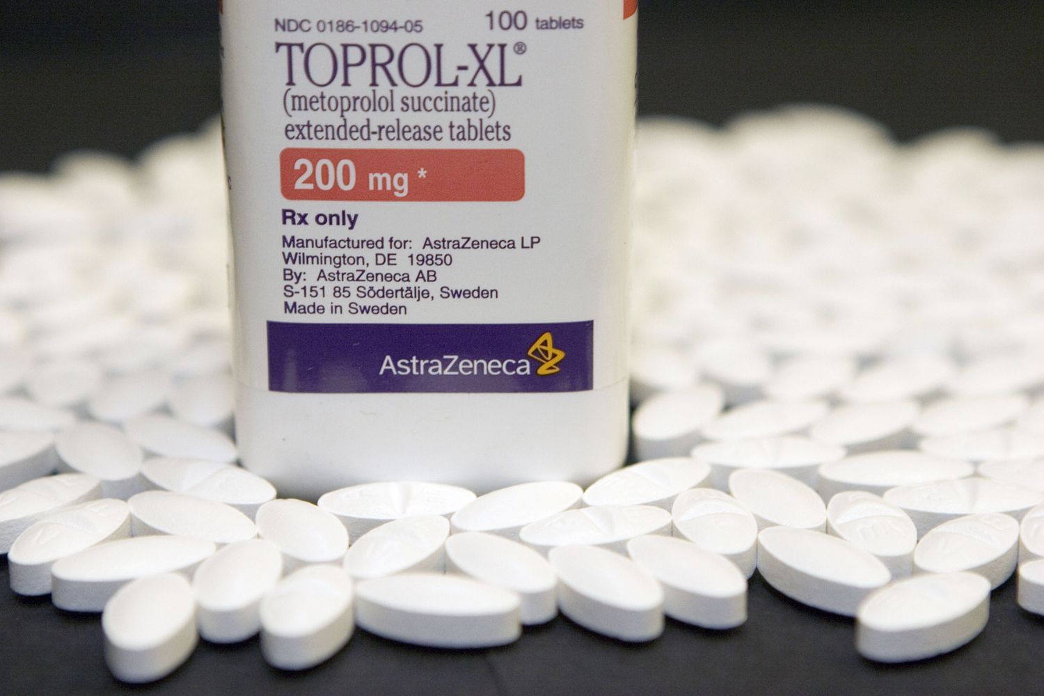 A bottle of Toprol-XL 200 mg tablets on a dark surface.