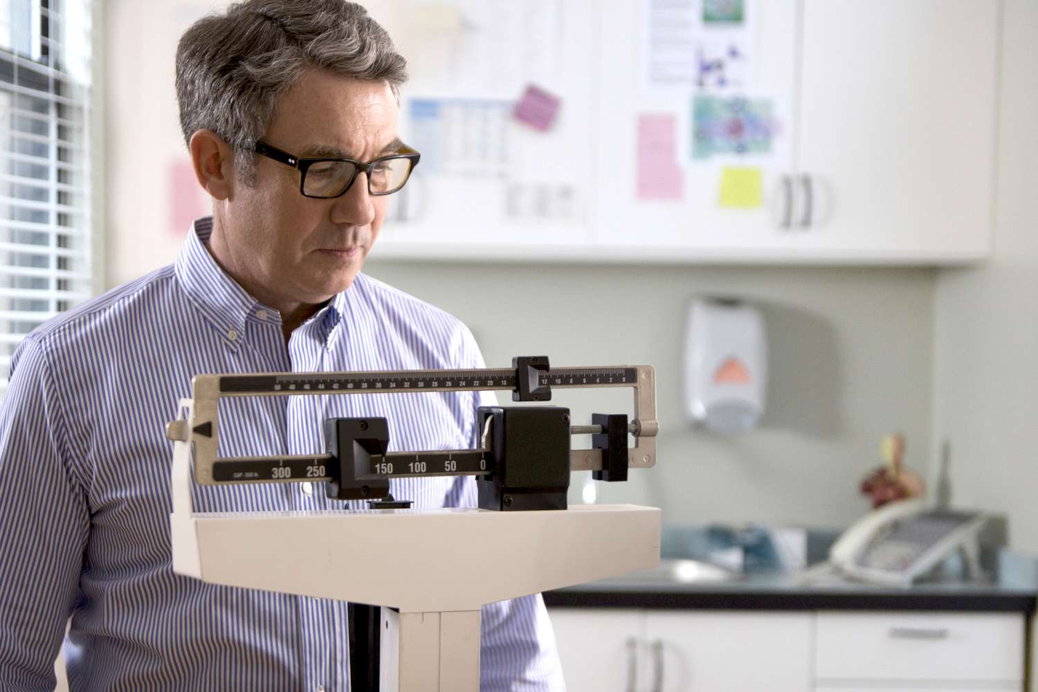 A mature male standing on a weighing scale to check his body weight.