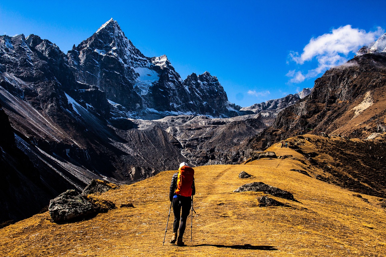 An energetic individual hiking on a mountain ridge overlooking a valley