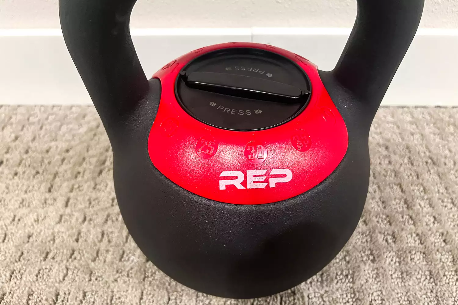 Close-up of the red weight selection dial on a REP Fitness adjustable kettlebell.