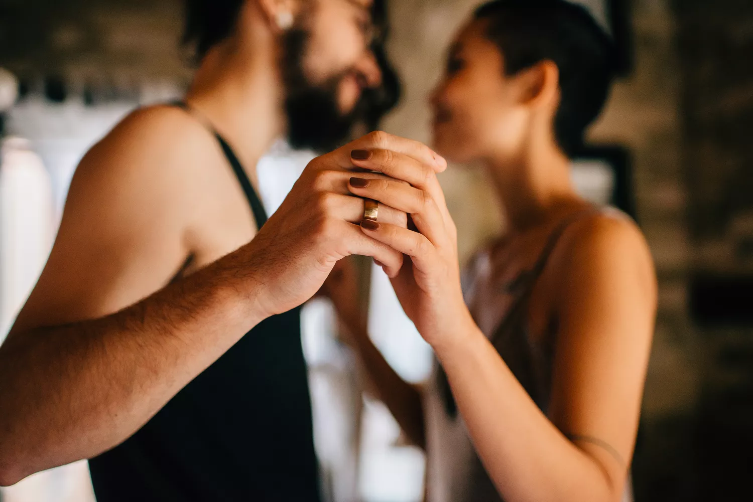 A couple slow dancing at home in an intimate setting.