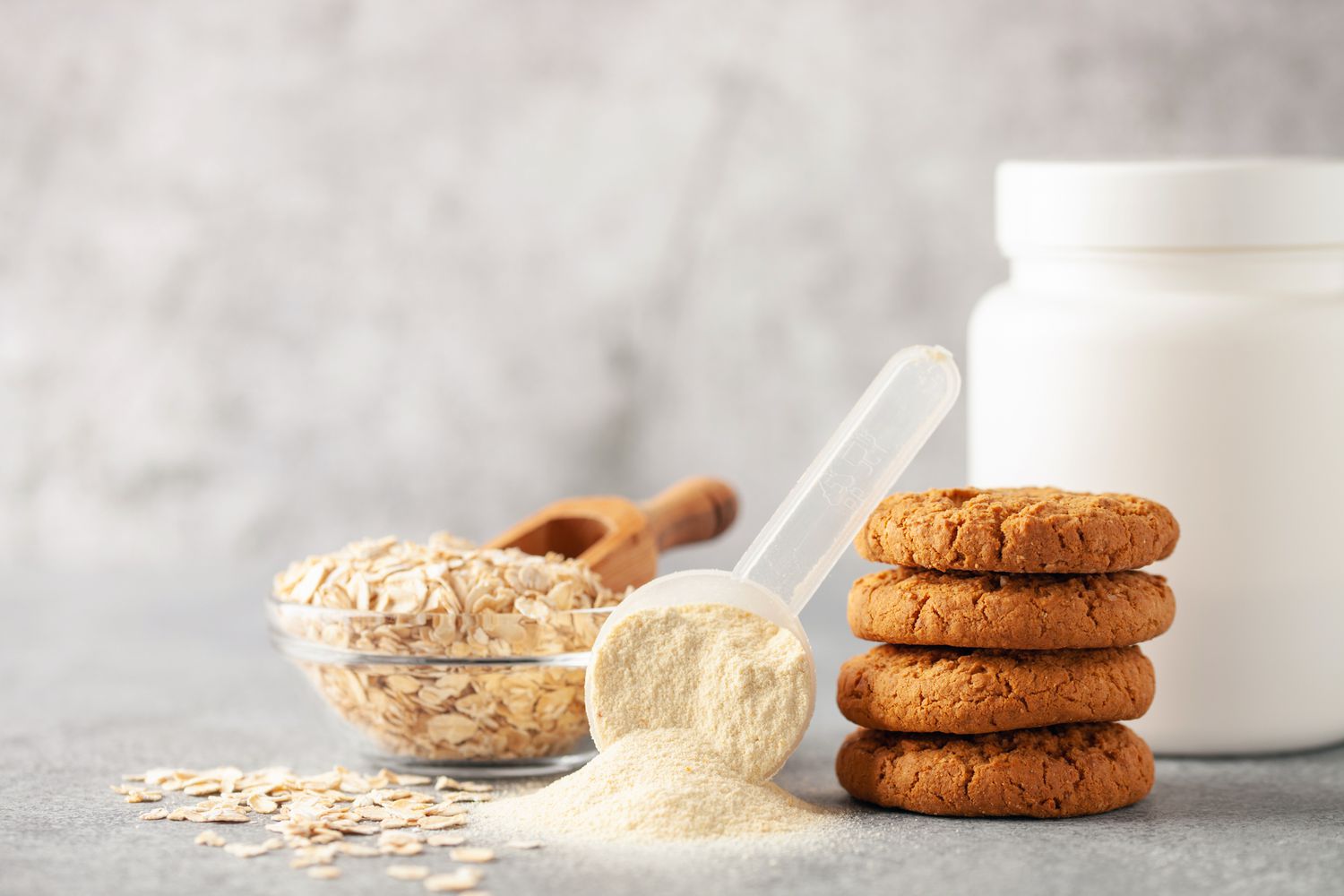A variety of healthy food components and protein supplements organized on a kitchen surface.