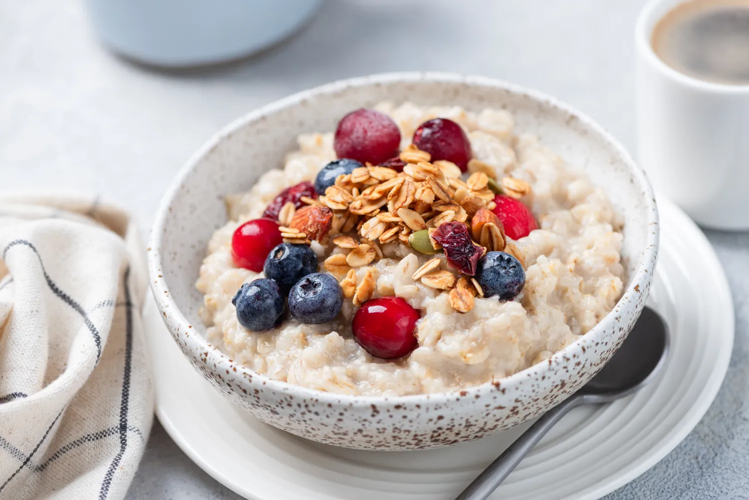 A bowl of oatmeal topped with fresh berries and crunchy granola.