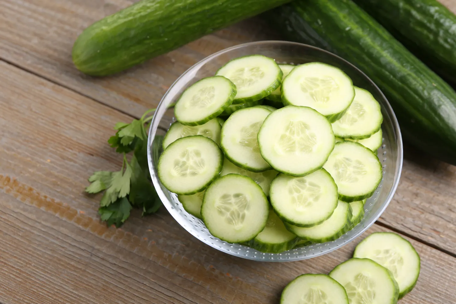 Sliced fresh cucumber on a neutral background.