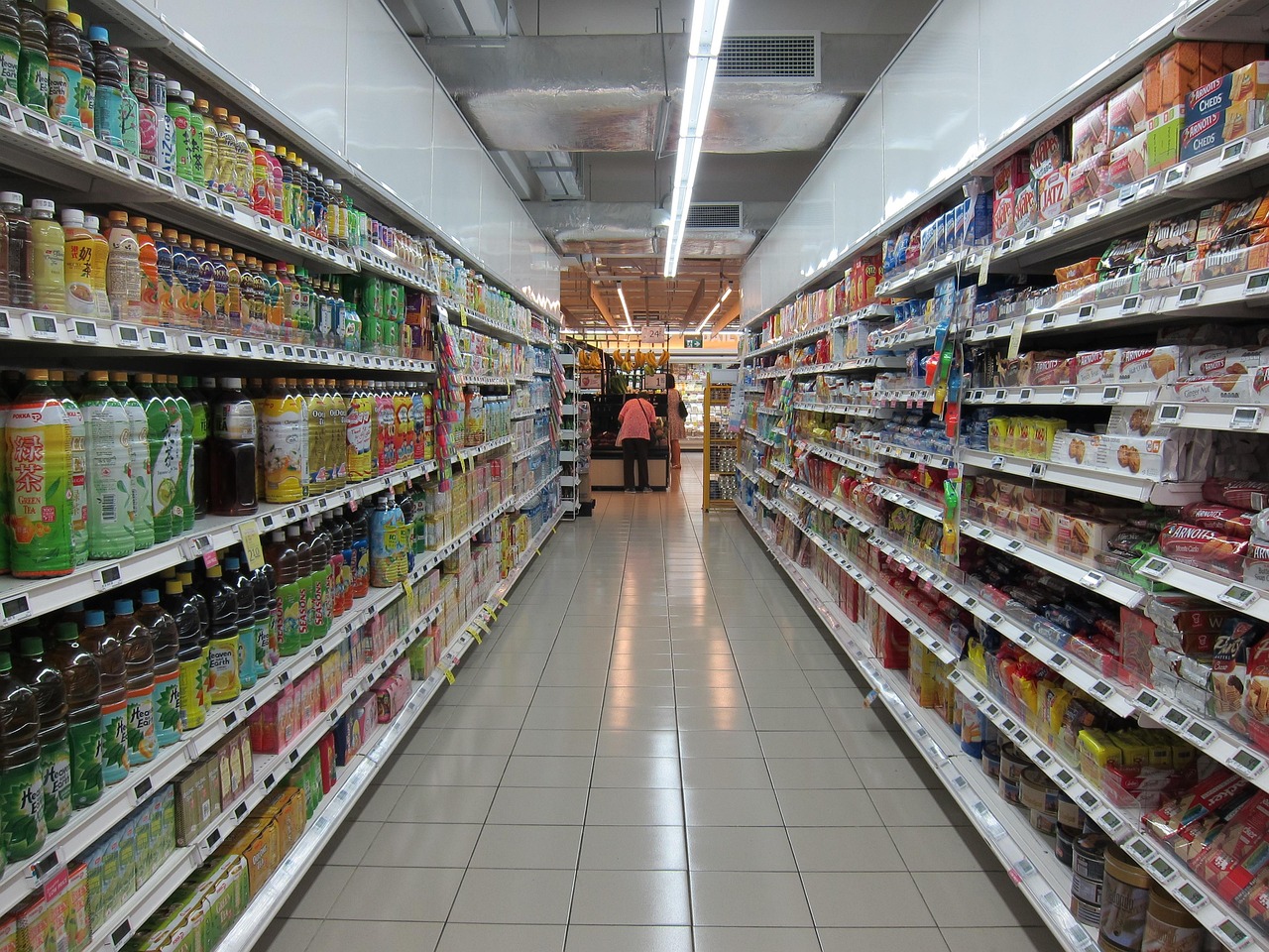 Long grocery store aisle filled with colorful snack boxes and bright packaging