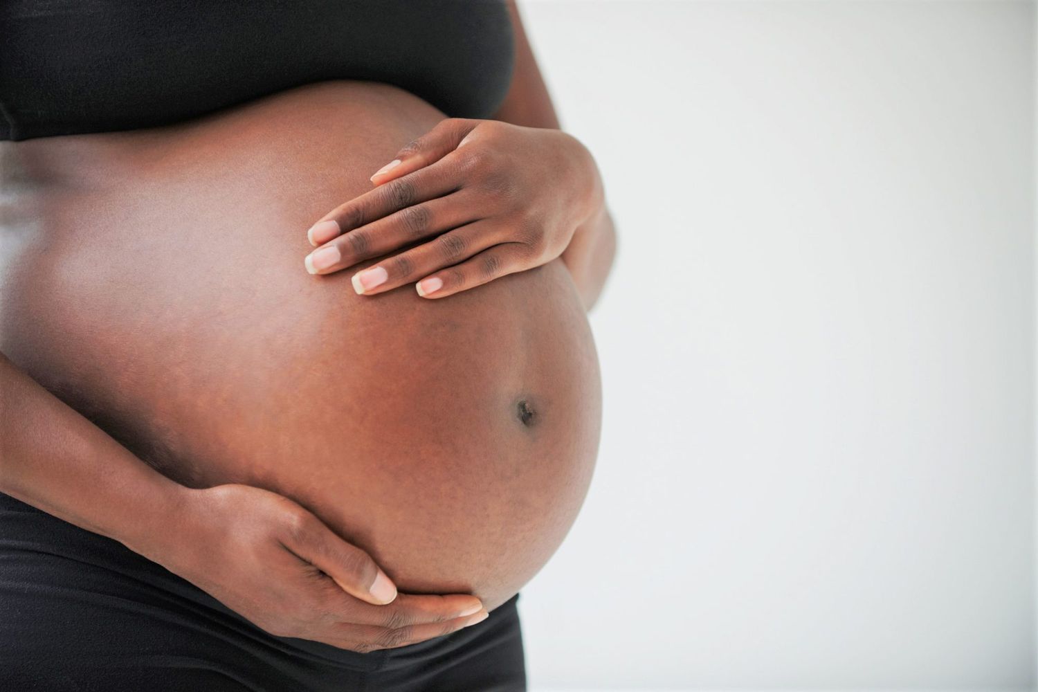 A woman touching her abdomen, representing physical wellness and internal health.