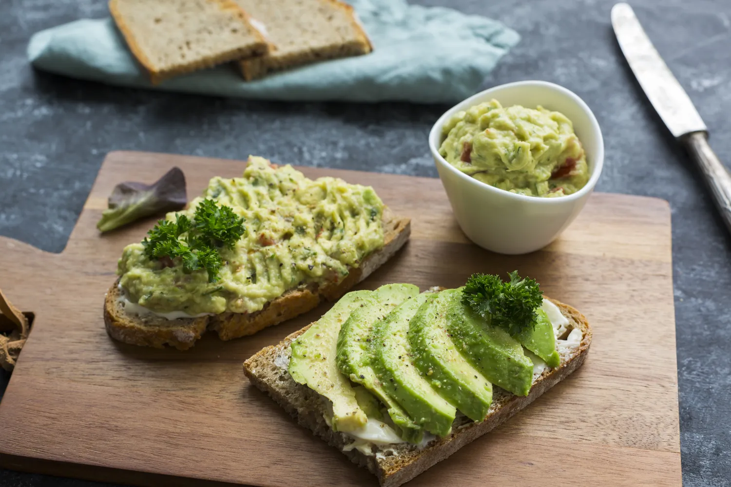 Sliced avocado on two pieces of toasted whole-grain bread.