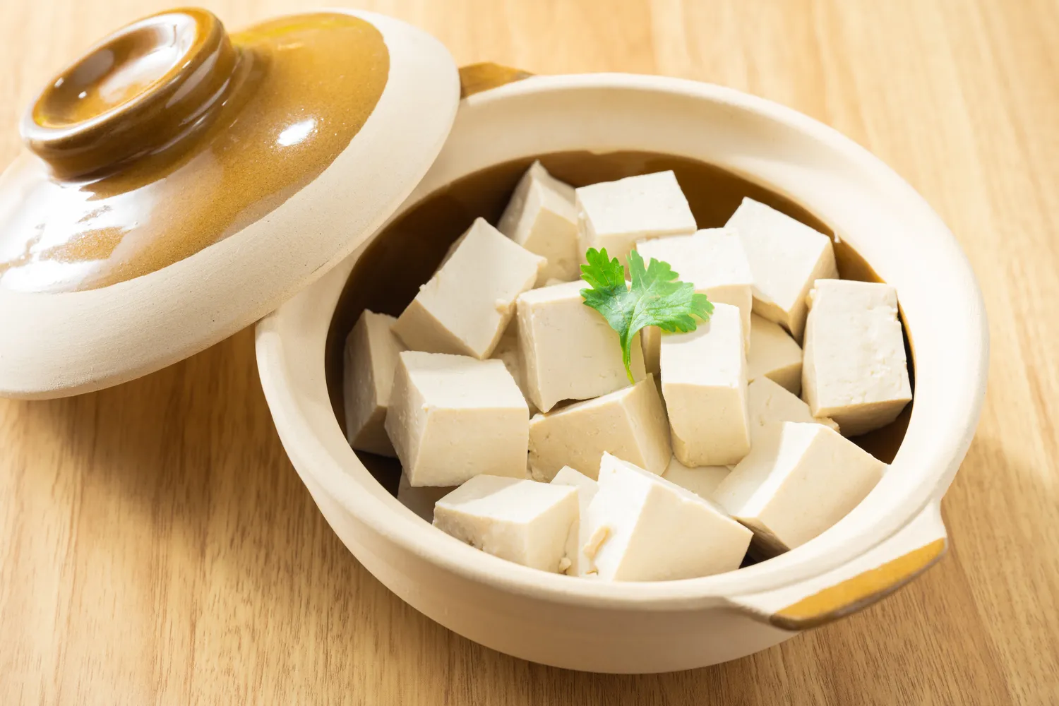 Cubed tofu garnished with parsley in a small ceramic pot.
