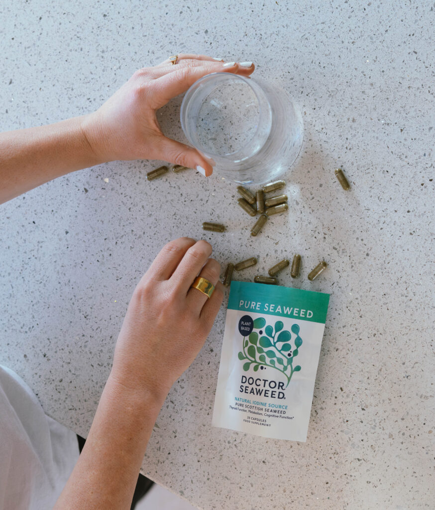 An overhead shot of a healthy breakfast bowl next to seaweed capsules.