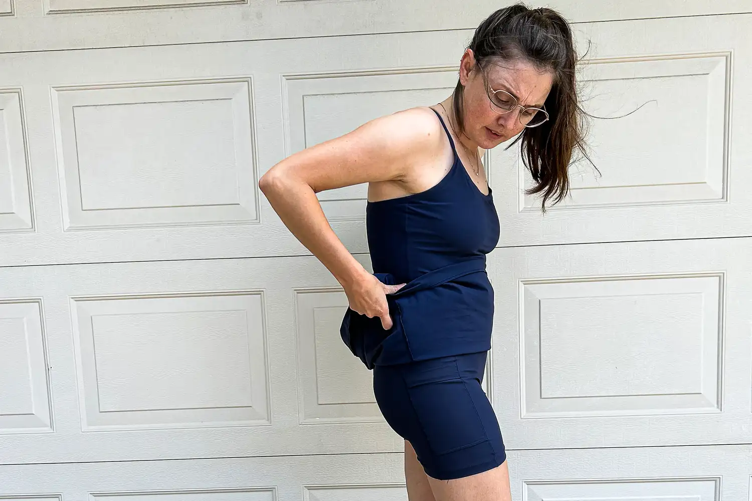 A person lifting the skirt of an Outdoor Voices dress to show the built-in shorts.