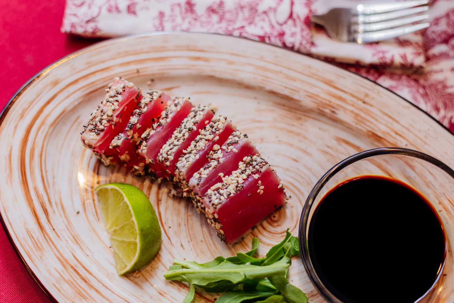 A plate of seared tuna with lime and sesame.